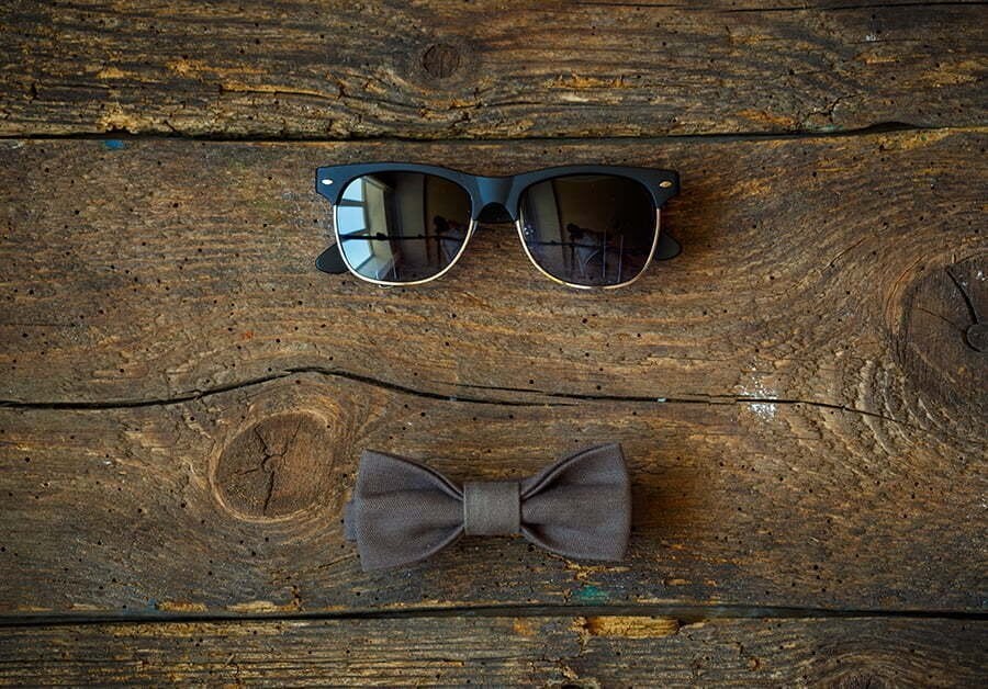sunglasses and bow tie on a wooden background