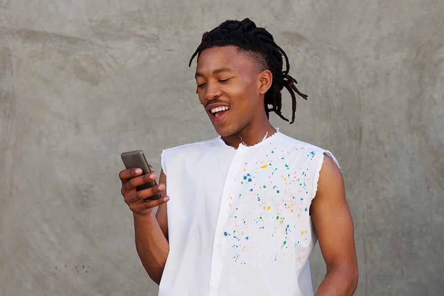 portrait of african man laughing with mobile phone